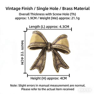 May include: A vintage-finish brass bow-shaped decorative element. The bow measures approximately 4.3 cm in length and 4 cm in height. The overall thickness is approximately 1.9 cm. The weight is approximately 21.1 grams.