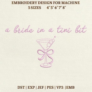 May include: Pink embroidery design for machine embroidery. The design features the text "a bride in a tini bit" above a martini glass with a bow. The design is available in 5 sizes: 10 cm, 13 cm, 15 cm, 18 cm, and 20 cm.