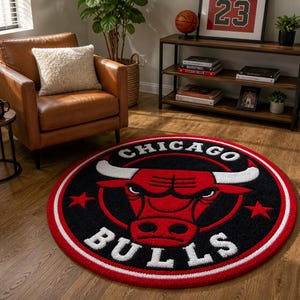 May include: A round rug featuring the Chicago Bulls logo in red, black, and white. The rug has a red border and the team name is prominently displayed. The rug is on a hardwood floor in a living room setting.