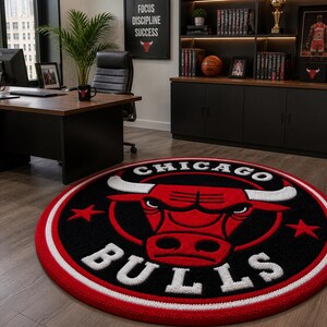 May include: A round rug featuring the Chicago Bulls logo in red, black, and white. The logo includes a red bull head with white horns and the words "CHICAGO BULLS" in a circular design. The rug has a red border.