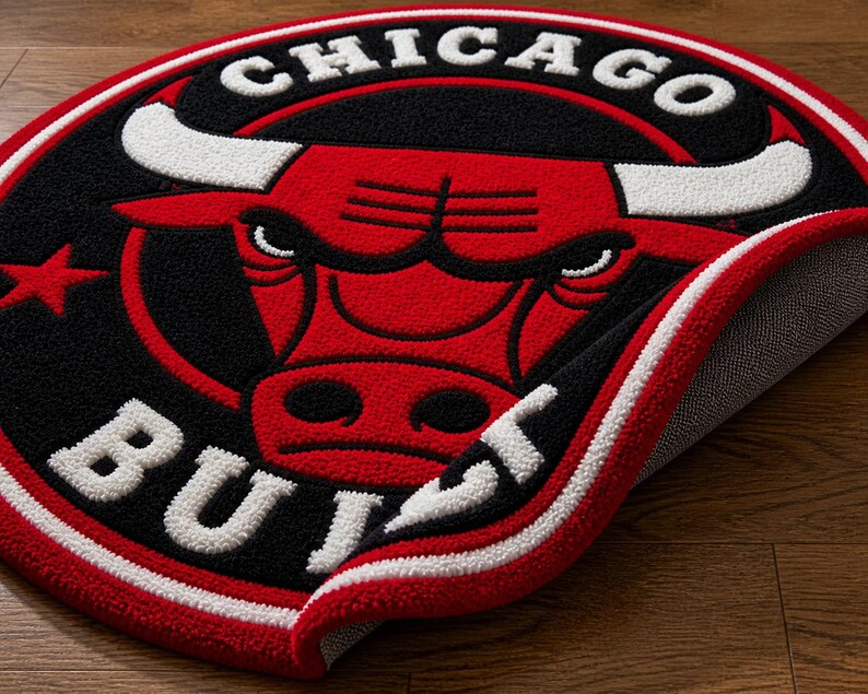May include: A round rug featuring the Chicago Bulls logo. The rug has a red, black, and white color scheme. The logo includes a red bull head with white horns, the words "CHICAGO" and "BULLS" in white.