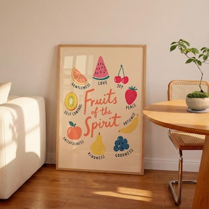 May include: A rectangular wall art print on a light beige background featuring the text Fruits of the Spirit in the center. Surrounding the text are illustrations of a slice of orange, watermelon, cherries, strawberry, banana, blueberries, pear, apple, and kiwi.