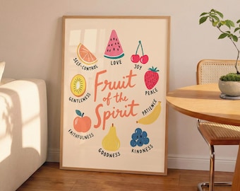 May include: A framed wall art print on a light cream background featuring the text Fruit of the Spirit in orange. Surrounding the text are illustrations of fruit including a watermelon slice, cherries, strawberry, banana, blueberries, pear, apple, kiwi, and orange slice with labels.