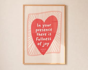 May include: A framed wall art print featuring a large red heart centered on a light background. Inside the heart, the white text reads: In your presence there is Fullness of joy PSALM 16:11. The heart is surrounded by a light pink sketched border.