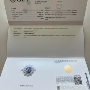 May include: A GIA Gemological Report for a sapphire ring. The report details the oval-shaped blue sapphire's characteristics, including its weight of 3.58 carats and measurements of 9.28 x 7.02 x 5.33 mm. The ring is set in white metal with near-colorless round brilliants.