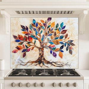May include: A colorful tree design on a kitchen backsplash. The artwork features a tree with a brown trunk and roots, and vibrant leaves in shades of red, orange, blue, and purple. The backsplash is installed above a white stove.