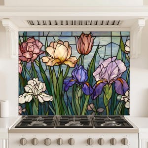 May include: A colorful stained glass backsplash featuring various flowers, including irises, tulips, and roses. The flowers are in shades of pink, yellow, purple, and white, with green stems and leaves against a blue background. The backsplash is installed above a white stove.