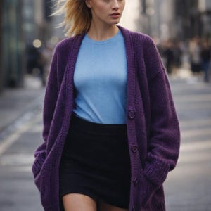 May include: A woman wearing a purple cardigan over a light blue sweater and a black skirt. The cardigan has large buttons and pockets. The outfit is worn outdoors on a city street.