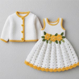 以下が含まれることがあります： 白のクロシェ編みドレスと、お揃いのジャケットのセット。ノースリーブのドレスは黄色の花のアクセントとスカラップの裾が特徴です。ジャケットは黄色のトリムとボタンが付いています。このセットは手作りの繊細なデザインです。