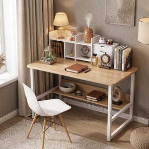 May include: A light wood desk with a white metal frame and a white hutch featuring multiple shelves and small drawers. The desk includes a lower storage shelf, a brown notebook, and a white chair with wooden legs. Various decorative items sit on top.