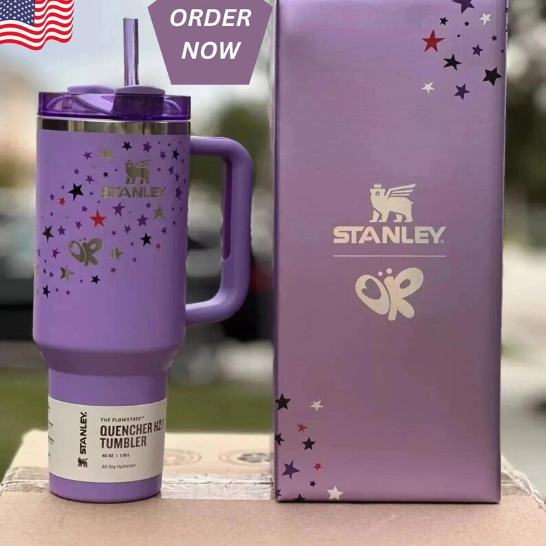 May include: A purple Stanley Quencher H2.0 FlowState tumbler with a handle, straw, and lid. The tumbler is decorated with star and butterfly designs. The box next to it has the Stanley logo and matching star designs. The text "ORDER NOW" is in the top right corner.