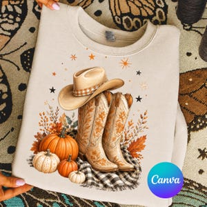Puede incluir: Una sudadera beige de cuello redondo con un estampado gráfico de un sombrero de vaquero beige sobre un par de botas de vaquero beige. El diseño incluye calabazas naranjas, hojas de otoño y pequeñas estrellas negras y naranjas.