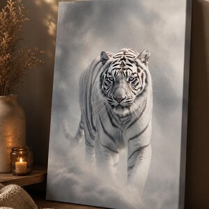 Könnte beinhalten: Ein rechteckiger Leinwanddruck, der einen weißen Tiger mit schwarzen Streifen zeigt, der durch eine neblige, grautönige Umgebung nach vorne läuft. Der Tiger hat stechende, helle Augen und ist in einer frontalen Haltung mit sichtbarem Schwanz abgebildet.