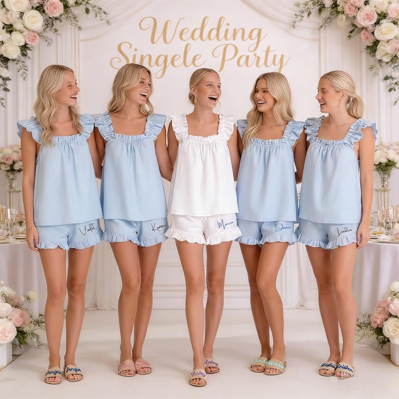 K&ouml;nnte beinhalten: F&uuml;nf Frauen in passenden Pyjama-Sets. Vier tragen hellblaue Sets mit R&uuml;schenoberteilen und Shorts, eine ein wei&szlig;es Set. Die Shorts sind mit Namen bestickt. Im Hintergrund steht der Text "Wedding Singele Party".