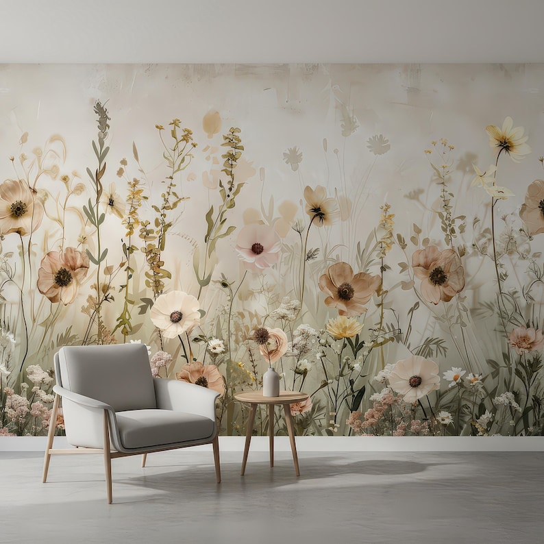 May include: A serene interior scene featuring a floral wallpaper with soft, muted tones of beige, peach, and green. A modern gray armchair and a small wooden side table with a vase are in front of the wallpaper. The room has a minimalist aesthetic.