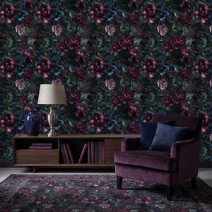 May include: A dark floral wallpaper featuring a dense pattern of burgundy, purple, and blue flowers against a black background. The image includes a matching rug, a purple armchair, and a wooden cabinet with a lamp and vase.