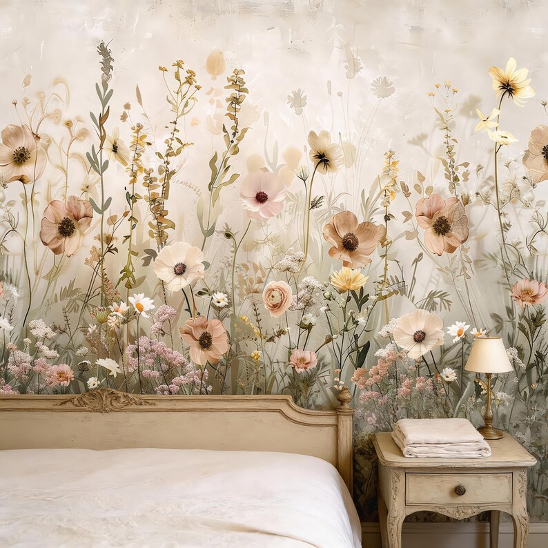 May include: A bedroom with a floral wallpaper featuring a variety of flowers in shades of peach, pink, and cream. The wallpaper creates a serene backdrop for a bed with a cream-colored headboard and a nightstand with a lamp.