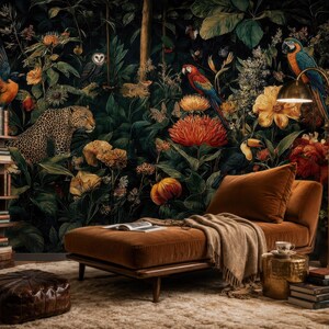 Pu&ograve; includere: Un interno con carta da parati botanica scura raffigurante leopardi, pappagalli e gufi. Una chaise longue in velluto marrone con una coperta beige si trova vicino a una lampada da terra dorata, un tavolino in ottone con una tazza e una libreria in legno.