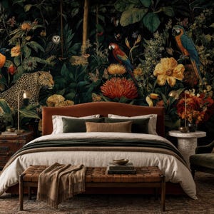 Pu&ograve; includere: Una camera da letto con un letto imbottito color ruggine, biancheria bianca e verde scuro, una panca in pelle marrone e un baule in legno scuro. La parete dietro il letto presenta un murale scuro con un leopardo, pappagalli e fiori.
