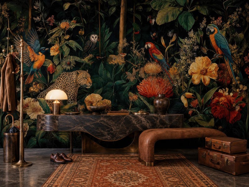 Pu&ograve; includere: Un murale con carta da parati dai toni scuri che presenta una fitta scena nella giungla con un leopardo, variopinti pappagalli, un gufo e grandi fiori tropicali. La scena include una console in marmo scuro, una panca in pelle marrone e due valigie vintage.