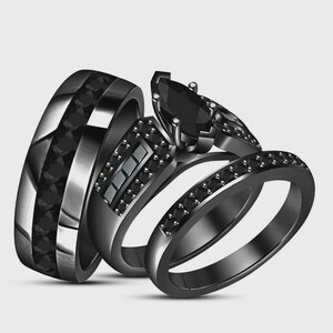 May include: Three black rings. One ring has a wide band with a series of black stones. Another ring has a marquise-cut black stone and smaller stones. The third ring is a thin band with small black stones.