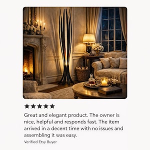 May include: A striking black floor lamp with an unusual, abstract form. The lamp features a series of vertical, curved sections, giving it an open, light appearance. The lamp is in a living room setting with a fireplace, sofa, and side table.