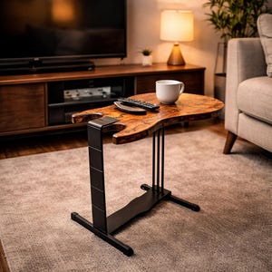 Puede incluir: Una mesa auxiliar con forma de guitarra con una tapa de madera natural. La mesa tiene una estructura y patas de metal negro. Una taza blanca y un mando a distancia están sobre la mesa. La mesa está en un salón.