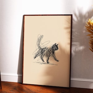 May include: A rectangular framed wall art piece featuring a black ink scribble drawing of a cat on a solid beige background. The cat is depicted in a walking pose with its tail held high, rendered entirely through chaotic, overlapping black lines.