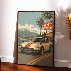 May include: A framed poster featuring a white sports car with red racing stripes driving on a coastal road. The background shows palm trees, mountains, and a sign that reads Pacific DRIVE-IN, GOOD FOOD, COLD DRINKS, OPEN 24 HOURS. The car has a license plate 7XJR193.