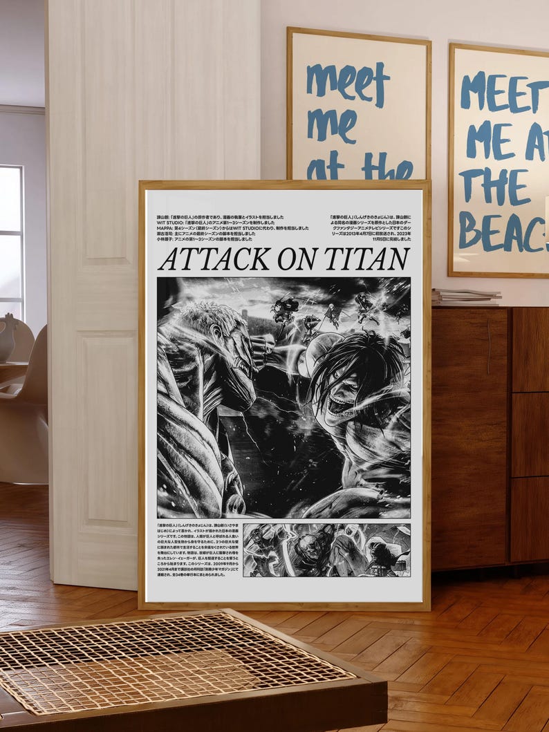 May include: A framed black and white Attack on Titan poster. The poster features manga-style illustrations of characters in action. The title "ATTACK ON TITAN" is prominently displayed. Two other framed posters with the text "meet me at the beach" are visible.