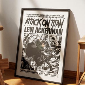 May include: A framed poster featuring the text "ATTACK ON TITAN" and "LEVI ACKERMAN" in bold, stylized lettering. The artwork depicts a manga-style illustration of a character in action, with Japanese text at the top and bottom. The poster is in a black frame.