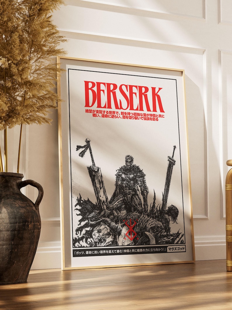May include: A framed poster with the word "BERSERK" in red, above Japanese text. The black and white illustration depicts a warrior with swords and a graphic scene. The poster is in a gold frame, leaning against a wall.