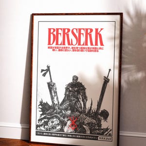 May include: A framed poster with the word "BERSERK" in red, above a black and white illustration of a warrior with swords. Japanese text is also present. The poster is displayed on a white wall.