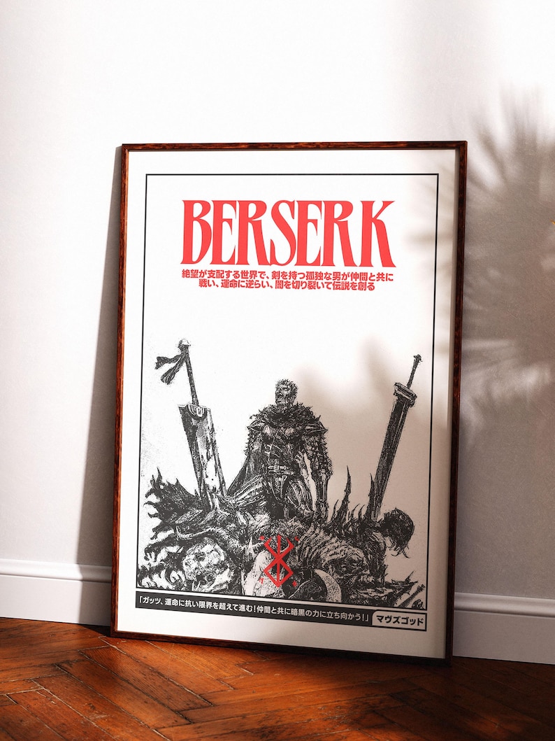May include: A framed poster with the word "BERSERK" in red, above a black and white illustration of a warrior with swords. Japanese text is also present. The poster is displayed on a white wall.