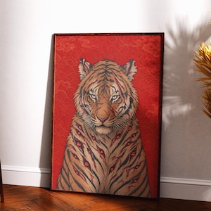 Op de afbeelding: Een ingelijste rechthoekige wandkunstprint met een tijger met oranje en zwarte strepen tegen een levendige rode achtergrond. De tijger heeft meerdere rode ogen in de vacht en zichtbare littekens, tegen een achtergrond met golfpatroon.