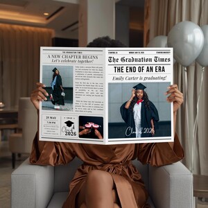 May include: A person holding a newspaper titled "The Graduation Times" with the headline "A New Chapter Begins." The newspaper features a graduation photo and the text "Class of 2026."