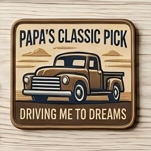 May include: A rectangular sign with rounded corners featuring a brown vintage pickup truck illustration. The text reads PAPA'S CLASSIC PICK at the top and DRIVING ME TO DREAMS at the bottom in black lettering against a light tan background.