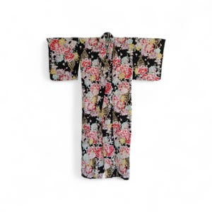 Puede incluir: Un kimono negro con un vibrante estampado floral con flores rosas, rojas y amarillas. El kimono tiene mangas anchas y un diseño largo y fluido, perfecto para un look tradicional o moderno.