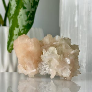 May include: A cluster of pink and white celestite crystals with a rough, natural texture.