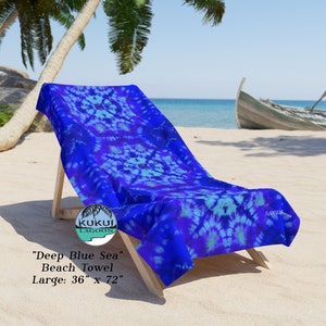 May include: A blue and purple tie-dye beach towel with the text "KUKUI LAGOON" and "Deep Blue Sea" Beach Towel Large: 36" x 72"