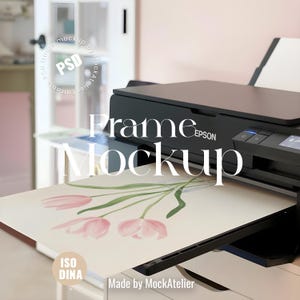 May include: A black Epson printer is shown with a print of pink tulips on a white paper. The words "Frame Mockup" are overlaid on the image. The image is in a well-lit room with a pink wall and a white door.