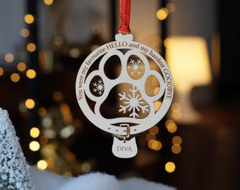 May include: A wooden Christmas ornament with a paw print design, snowflakes, and the text "You were my favourite HELLO and my hardest GOODBYE." A small tag reads "DIVA." The ornament hangs from a red ribbon.