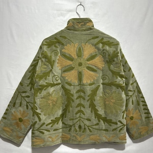 May include: A light green jacket with long sleeves and a high collar. The jacket is adorned with intricate floral embroidery in shades of gold and green. The embroidery is centered on the back and sleeves.