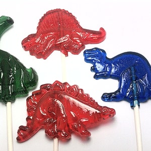 May include: Four colorful dinosaur lollipops on sticks. The lollipops are green, red, and blue.