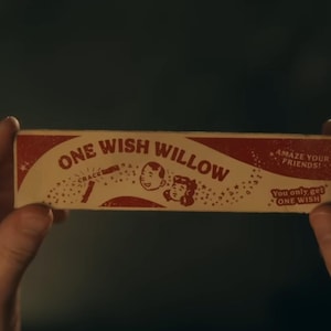 Puede incluir: Una caja rectangular con el texto "ONE WISH WILLOW" en rojo y blanco. La caja presenta ilustraciones de un niño y una niña, junto con las frases "CRACK" y "AMAZE YOUR FRIENDS!" La caja también dice "You only get ONE WISH."