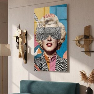 May include: A vertical glass wall art featuring a retro blonde woman portrait with black-and-white zebra pattern sunglasses, red lips, and a colorful geometric background.