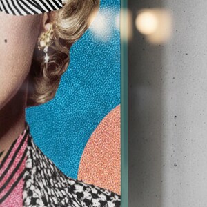 May include: A vertical glass wall art featuring a retro blonde woman portrait with black-and-white zebra pattern sunglasses, red lips, and a colorful geometric background.
