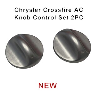 May include: Two silver Chrysler Crossfire AC Knob Control Set 2PC. The knobs are round with a curved, ridged design. The word "NEW" is printed in red at the bottom of the image.