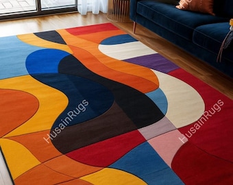 May include: A colorful area rug with an abstract design. The rug features a vibrant mix of colors, including red, orange, yellow, blue, and purple. The design is composed of curved and geometric shapes, creating a modern and artistic look.