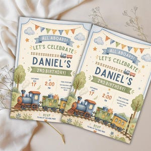 May include: Two rectangular birthday invitation cards featuring a watercolor train theme. The text reads: ALL ABOARD! LET'S CELEBRATE DANIEL'S 2ND BIRTHDAY! SATURDAY MAY 17 AT 2:00 PM THE STATION 1212 RAILROAD LANE AUSTIN, TEXAS 78701 RSVP TO MIA AT 123.456.7890.